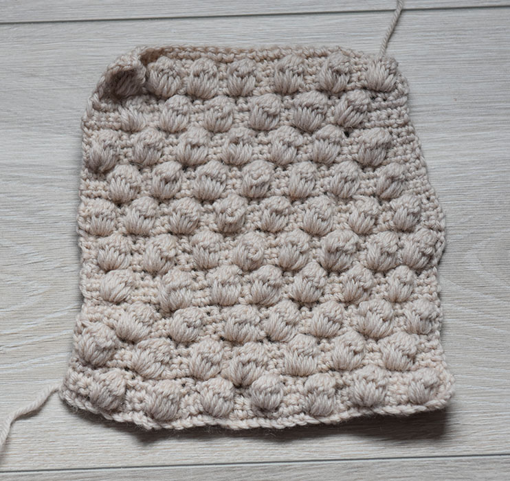 Heklet lapp i 20 x 20 cm Ananasmønster: Slik gjør du: - Legg opp et antall luftmasker (lm) delbart med 4 + 3, 1 lm til å snu med Rad 1, 2 og 3: - Hekle 1 fastmaske (fm) i hver maske (m), radene ut. - Snu med 1 lm. Rad 4: - Hekle 1 fm i hver av de første 3 m. - Hekle 1 ananas på følgende måte: Stikk nålen inn i neste m, 1 kast, trekk tråden igjennom #1 kast, stikk nålen inn i samme maske 2 rader lenger ned (= første rad), 1 kast, trekk tråden igjennom, 1 kast, trekk tråden igjennom de 2 ytterste maskene på nålen# GJENTA fra # til # 6 ganger. - 1 kast, trekk tråden gjennom alle 8 m på nålen (= 1 ananas). - Hekle 1 fm i hver av de neste 3 fm - *Hekle 1 ananas, 3 fm* GJENTA fra * til * raden ut, snu med 1 lm. Rad 5, 6 og 7: - Hekle 1 fastmaske (fm) i hver maske (m), radene ut. - Snu med 1 lm. Rad 8: - Hekle 1 fm, *1 ananas, 3 fm* GJENTA fra * til * raden ut, frem til det er 2 m igjen. Hekle 1 ananas, 1 fm. Snu med 1 lm. Gjenta rad 1 til 8.