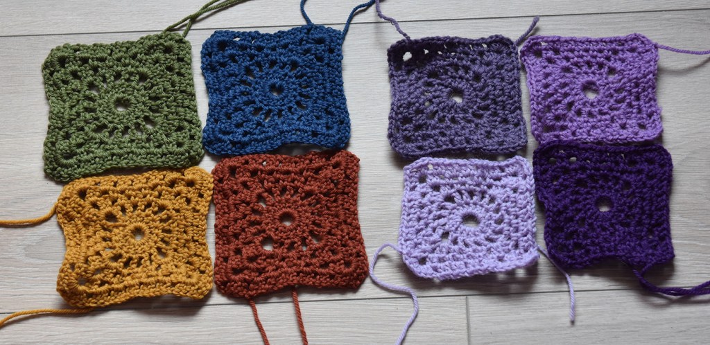 Kvadrat 1 (- hekling rundt) - Kvadrat med lite hjul i midten Slik gjør hekler du Kvadrat med lite hjul i midten : -Legg opp 6 luftmasker (lm), og sett i ring med 1 kjedemaske (kjm) i første lm. Omgang 1: - 3 lm - 15 staver (st) i ringen. - Lukk med 1 kjm i 3 lm (av de 3 som du startet med) Omgang 2: - 5 lm, - *1 st i neste st, 2 lm* GJENTA fra * til * 14 ganger til. Lukk med 1 kjm i 3 lm (= 16 hull). Omgang 3: - 1 kjm i første hull. - 3 lm - (1 st, 3 lm, 2 st) i samme hull. - *(2 lm, 1 fm i neste hull 3 ganger), 2 lm, (2 st, 3 lm, 2 st) i neste hull * GJENTA fra * til * 2 ganger til, 2 lm, 1 fm i neste hull 3 ganger, 2 lm, slutt med 1 kjm i 3 lm. Omgang 4: - 1 kjm i 3 lm-hullet. - 3 lm, (1 st, 3 lm, 2 st) i samme hull. - *(2 lm, 1 fm i 2 lm-hullet) 4 ganger. 2 lm, (2 st, 3 lm, 2 st) i 3 lm-hullet*. GJENTA fra * til * 2 ganger til. - (2 lm, 1 fm i 2 lm-hullet) 4 ganger, 2 lm. - Slutt med 1 kjm i 3 lm. Omgang 5: - 1 kjm i 3 lm hullet. - (2 st, 2 lm, 3 st) i samme hull. - *(1 lm, 2 st, i 2 lm-hullet) 5 ganger. 1 lm, (3 st, 2 lm, 3 st) i 3 lm-hullet*. GJENTA fra * til * 2 ganger til. - (1 lm, 2 st i 2 lm-hullet) 5 ganger, 1 lm. - Slutt med 1 kjm i 3. lm