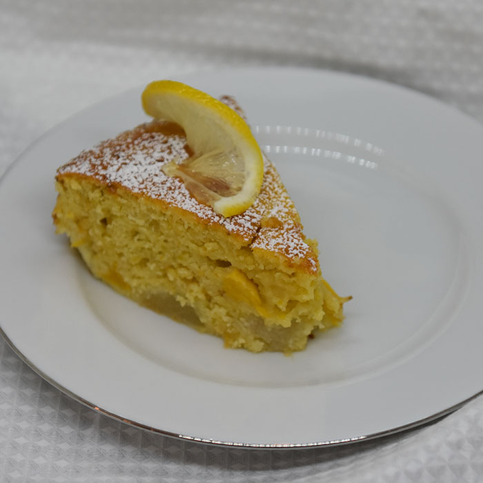 Spenstig sitronkake med pærer og fersken Ingredienser: 125 g Smør (smeltet) 2 Pærer (godt modne) 2 Fersken (godt modne) 2 Sitroner (skall og saft) 4 Egg 2 dl Sukker 3 ½ dl Hvetemel 1 ts Bakepulver