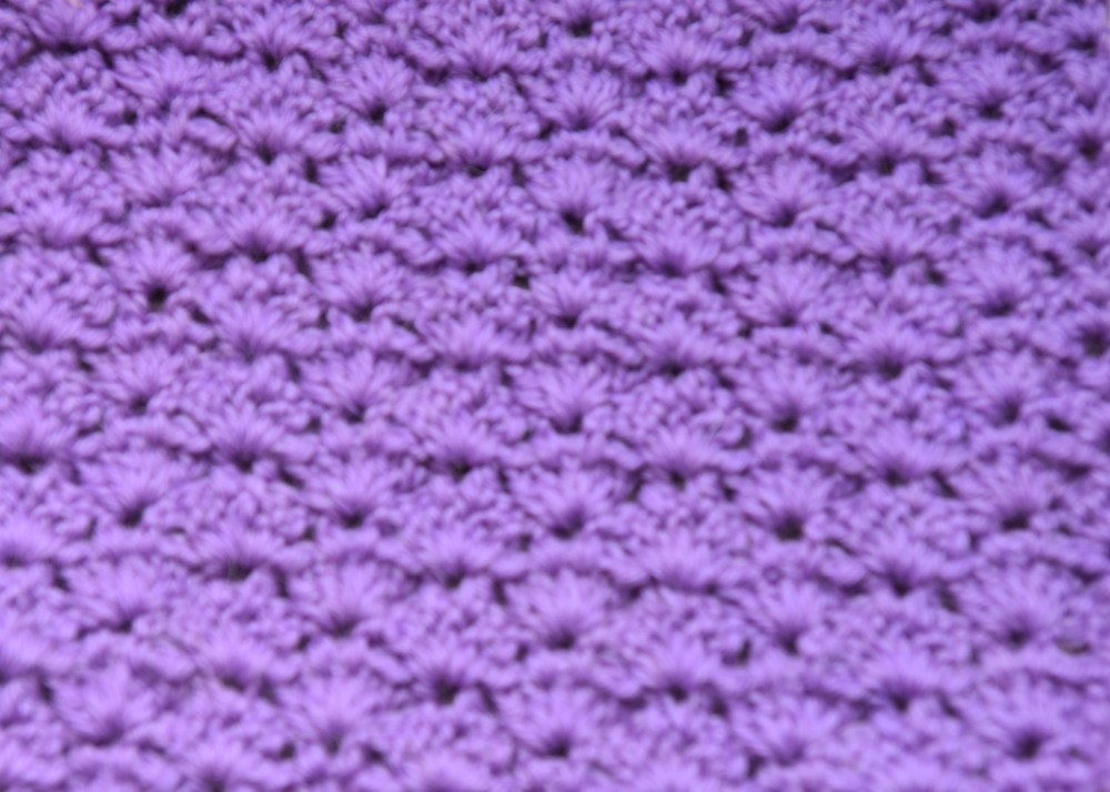 Viftemønster - mønstervariasjon med staver og luftmasker Slik gjør du (viftemønster): - Legg opp et antall luftmasker (lm) delbart med 7 + 4, 3 lm til å snu med Rad 1: - 1 stav (st) i 4. lm fra nålen. - *Hopp over 2 m, 5 st i neste m, hopp over 2 m, 1 st i hver av de neste 2 m* GJENTA fra * til * raden ut, men avslutt med å hoppe over 2 m, 3 st i siste m, snu med 3 lm. Rad 2: - 1 st mellom de to første st. -*5 st mellom de to enkelt st, 1 st mellom 2. og 3. av de 5 st fra forrige omg. 1 st mellom 3. og 4. av de 5 st fra forrige omgang* GJENTA fra * til * raden ut, men avslutt med 3 st mellom siste stav og snumaske, snu med 3 lm. GJENTA rad 2.