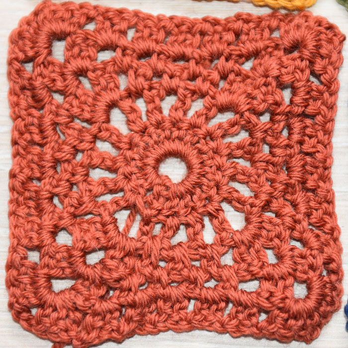 Kvadrat 1 (- hekling rundt) - Kvadrat med lite hjul i midten Slik gjør hekler du Kvadrat med lite hjul i midten : -Legg opp 6 luftmasker (lm), og sett i ring med 1 kjedemaske (kjm) i første lm. Omgang 1: - 3 lm - 15 staver (st) i ringen. - Lukk med 1 kjm i 3 lm (av de 3 som du startet med) Omgang 2: - 5 lm, - *1 st i neste st, 2 lm* GJENTA fra * til * 14 ganger til. Lukk med 1 kjm i 3 lm (= 16 hull). Omgang 3: - 1 kjm i første hull. - 3 lm - (1 st, 3 lm, 2 st) i samme hull. - *(2 lm, 1 fm i neste hull 3 ganger), 2 lm, (2 st, 3 lm, 2 st) i neste hull * GJENTA fra * til * 2 ganger til, 2 lm, 1 fm i neste hull 3 ganger, 2 lm, slutt med 1 kjm i 3 lm. Omgang 4: - 1 kjm i 3 lm-hullet. - 3 lm, (1 st, 3 lm, 2 st) i samme hull. - *(2 lm, 1 fm i 2 lm-hullet) 4 ganger. 2 lm, (2 st, 3 lm, 2 st) i 3 lm-hullet*. GJENTA fra * til * 2 ganger til. - (2 lm, 1 fm i 2 lm-hullet) 4 ganger, 2 lm. - Slutt med 1 kjm i 3 lm. Omgang 5: - 1 kjm i 3 lm hullet. - (2 st, 2 lm, 3 st) i samme hull. - *(1 lm, 2 st, i 2 lm-hullet) 5 ganger. 1 lm, (3 st, 2 lm, 3 st) i 3 lm-hullet*. GJENTA fra * til * 2 ganger til. - (1 lm, 2 st i 2 lm-hullet) 5 ganger, 1 lm. - Slutt med 1 kjm i 3. lm