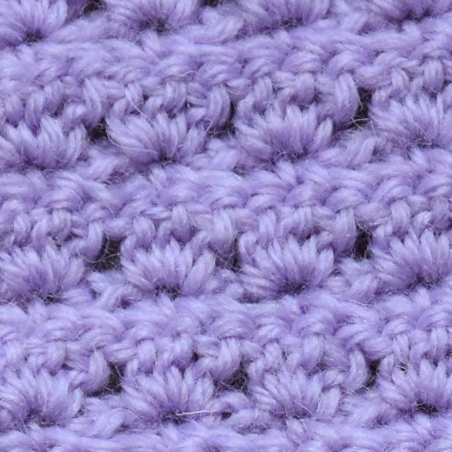 Lotusmønster - mønstervariasjon med fastmasker og staver Slik hekler du Lotusmønster - (mønstervariasjon med fastmasker og staver) - Legg opp et antall luftmasker (lm) delbart med 3 + 1, 1 lm til å snu med Rad 1: - 1 fastmaske (fm) i 2 maske (m) fra nålen. - *2 lm, hopp over 2 m, 1 fm i neste m* GJENTA fra * til * raden ut, snu med 3 lm. Rad 2: - 1 stav (st) i første fm - *3 st i neste fm* GJENTA fra * til * raden ut, men avslutt med 2 st i siste fm. Snu med 1 lm. Rad 3: - 1 fm i første st - *2 lm, 1 fm i den andre av de 3 st* GJENTA fra * til * raden ut, men avslutt med 2 lm, 1 fm i snumasken. Snu med 3 lm. GJENTA rad 2 og 3.