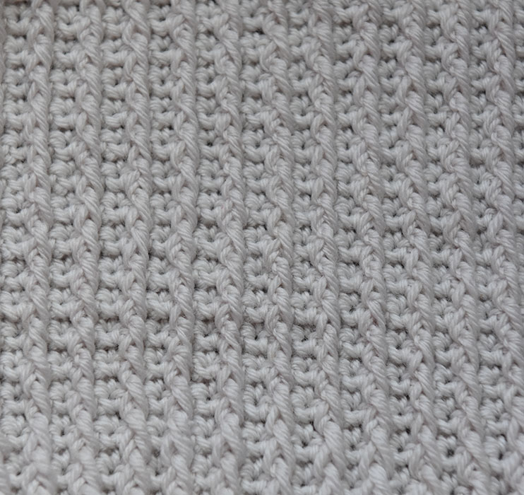 Relieffstav (Relieffst) Slik gjør du: - Legg opp et ujevnt antall luftmasker (lm) + 3 lm til å snu med Rad 1: - Hekle en rad med staver (st) i hver lm + 1 lm til å snu med Rad 2: - Hekle en rad med fastmasker (fm) i hver st + 2 lm til å snu med Rad 3: - * 1 kast, - Stikk nåla inn fra høyre mot venstre rundt staven i nederste rad. Hekle en st (= 1 relieffst) - Hopp over en fm - 1 fm i neste fm * GJENTA fra * til * raden ut - Slutt med 1 relieffst, og 1 fm - Snu med 1 lm Rad 4: - 1 fm i hver st raden ut - Snu med 2 lm Rad 5: - * Hekle 1 relieffst rundt relieffst på rad 3 - 1 fm (i neste fm) * GJENTA fra * til * raden ut, - Slutt med 1 fm - Snu med 1 lm Gjenta rad 4 og 5