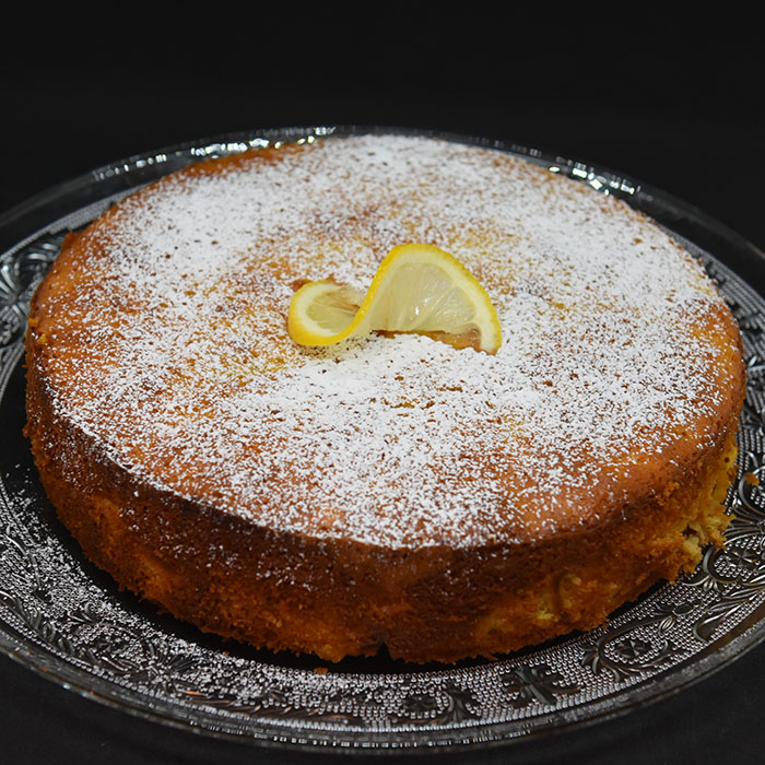 Spenstig sitronkake med pærer og fersken Ingredienser: 125 g Smør (smeltet) 2 Pærer (godt modne) 2 Fersken (godt modne) 2 Sitroner (skall og saft) 4 Egg 2 dl Sukker 3 ½ dl Hvetemel 1 ts Bakepulver