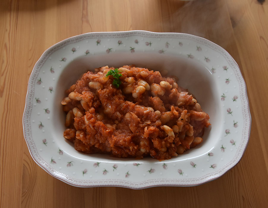 Bønner i tomatsaus Ingredienser: 1 bx Tomater (hakkete ca. 400 g) 400 g Hvite bønner (kokte eller hermetiske) 1-2 ss Margarin 1 Løk (finhakket) 2 fedd Hvitløk (finhakket) ¼ ts Kajennepepper ½ ts Sukker ½ ts Salt