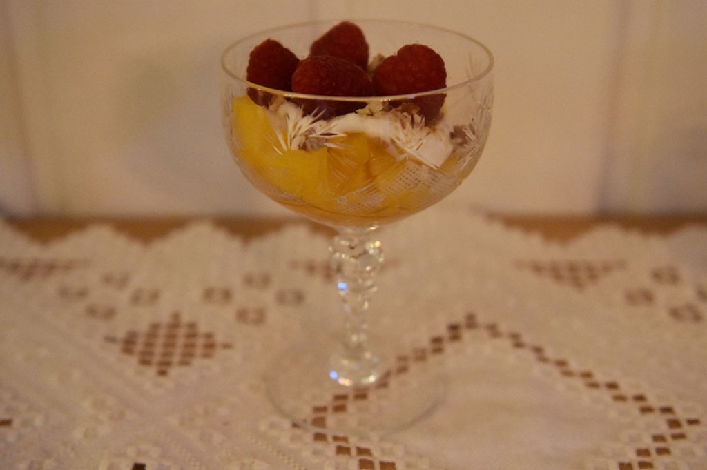 Fersken og bringebær med hvit sjokoladeyoghurt Ingredienser: 1 pk Bringebær (ferske) 4 Fersken (skjært i biter) 75 g Hvit sjokolade 200 g Gresk yoghurt (romtemperert) 50 g Pekannøtter 100 g Sukker