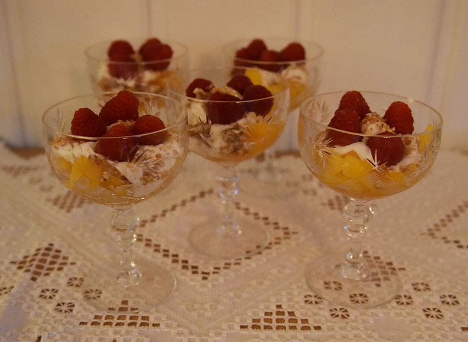 Fersken og bringebær med hvit sjokoladeyoghurt Ingredienser: 1 pk Bringebær (ferske) 4 Fersken (skjært i biter) 75 g Hvit sjokolade 200 g Gresk yoghurt (romtemperert) 50 g Pekannøtter 100 g Sukker