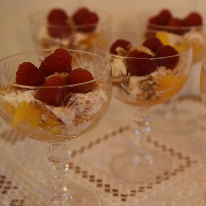 Fersken og bringebær med hvit sjokoladeyoghurt Ingredienser: 1 pk Bringebær (ferske) 4 Fersken (skjært i biter) 75 g Hvit sjokolade 200 g Gresk yoghurt (romtemperert) 50 g Pekannøtter 100 g Sukker