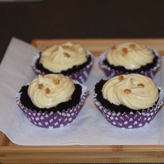 Mørke saftige sjokolademuffins med hvit sjokolade- og kremosttopping Ingredienser: 2 ½ Kaffe (varm og sterk) 2 ts Vaniljesukker 70 g Sjokolade (mørk) 2 Egg (romtempererte) 1 ¼ dl Olje (nøytral) 2 ½ Fløte 500 g Sukker 190 g Hvetemel 150 g Kakaopulver 1 ½ ts Natron ½ ts Bakepulver Hvit sjokoladeostekrem topping: 400 g Sjokolade (hvit) 350 g Smør (romtemperert) 200 g Melis 1 pk Philadelphiaost 1 ss Vaniljesukker 1 ss Limesaft (valgfritt)