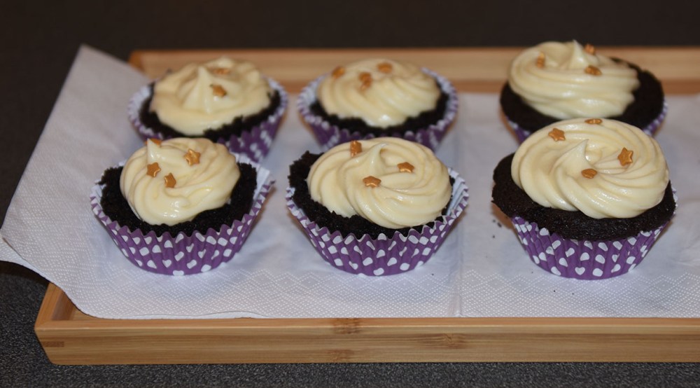 Mørke saftige sjokolademuffins med hvit sjokolade- og kremosttopping Ingredienser: 2 ½ Kaffe (varm og sterk) 2 ts Vaniljesukker 70 g Sjokolade (mørk) 2 Egg (romtempererte) 1 ¼ dl Olje (nøytral) 2 ½ Fløte 500 g Sukker 190 g Hvetemel 150 g Kakaopulver 1 ½ ts Natron ½ ts Bakepulver Hvit sjokoladeostekrem topping: 400 g Sjokolade (hvit) 350 g Smør (romtemperert) 200 g Melis 1 pk Philadelphiaost 1 ss Vaniljesukker 1 ss Limesaft (valgfritt)