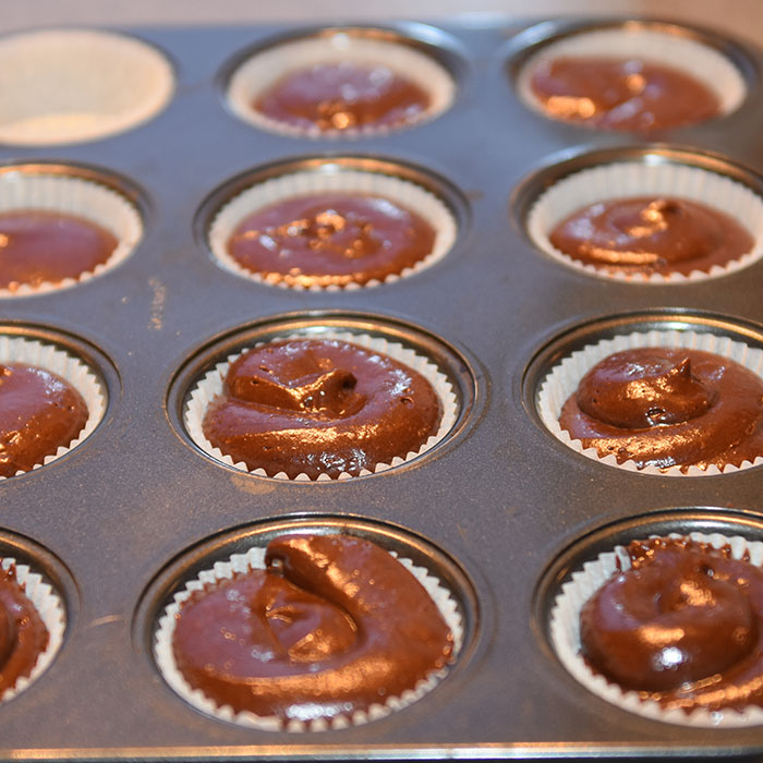 Mørke saftige sjokolademuffins med hvit sjokolade- og kremosttopping Ingredienser: 2 ½ Kaffe (varm og sterk) 2 ts Vaniljesukker 70 g Sjokolade (mørk) 2 Egg (romtempererte) 1 ¼ dl Olje (nøytral) 2 ½ Fløte 500 g Sukker 190 g Hvetemel 150 g Kakaopulver 1 ½ ts Natron ½ ts Bakepulver Hvit sjokoladeostekrem topping: 400 g Sjokolade (hvit) 350 g Smør (romtemperert) 200 g Melis 1 pk Philadelphiaost 1 ss Vaniljesukker 1 ss Limesaft (valgfritt)