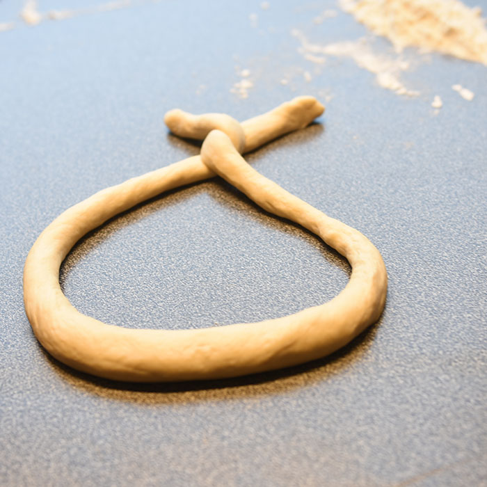 Pretzel (myke) Ingredienser: 2 ½ ts Tørrgjær 1 ¼ dl Vann (varmt ca. 38-45 grader) 1 ss Sirup (mørk) 450 g Hvetemel 1,2 dl Øl (pilsner) 2 ss Smør (romtemperert) 2 ts Salt 0,6 dl Natron 1 Eggeplomme 1 ss Vann (kaldt) Salt (flak eller korn)