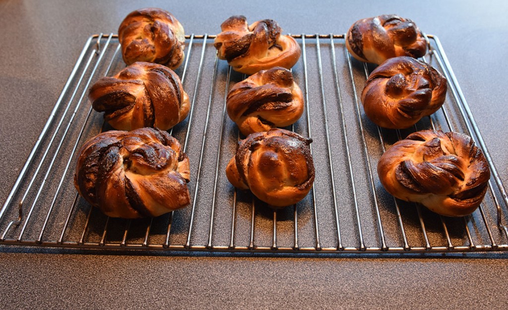 Sjokoladeknuter Ingredienser: 6 dl Melk 1 pk Gjær 1 kg Hvetemel 150 g Sukker 3 ts Flaksalt 3 ts Kardemomme 1 Egg 150 g Smør