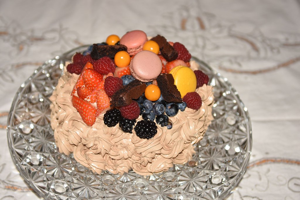 Idas Sjokoladekake med friske bær Ingredienser: Kakebunnen: 400 g Sukker (ca. 5 dl) 325 g Hvetemel (ca. 2 dl) 80 g Kakaopulver (ca. 2 ½ dl) 2 ts Bakepulver 2 ts Vaniljesukker 225 g Smør ½ dl Olje (nøytral) 4 Egg (romtempererte) 2 ¼ dl Melk 2 ¼ dl Kaffe (varm) Jordbærmousse: 500 g Jordbær (frosne) 6 pl Gelatin 3 ss Vann (kokende) 3 ss Sitron 3 dl Fløte 3 Egg 6 – 9 ss Sukker (ca. 1 dl) Pynt: 4 ss Smør 300 g Melis 1 ss Kakao 1 ts Vaniljesukker 3 ss Kaffe (sterk) Topping og dekorasjon: Bær (blandete) https://heidisboble.no/ @heidisboble