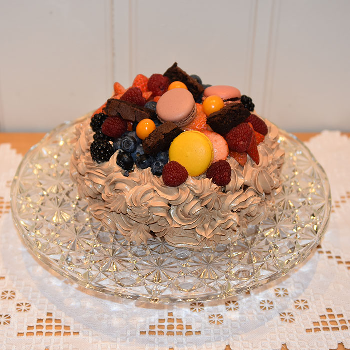 Idas Sjokoladekake med friske bær Ingredienser: Kakebunnen: 400 g Sukker (ca. 5 dl) 325 g Hvetemel (ca. 2 dl) 80 g Kakaopulver (ca. 2 ½ dl) 2 ts Bakepulver 2 ts Vaniljesukker 225 g Smør ½ dl Olje (nøytral) 4 Egg (romtempererte) 2 ¼ dl Melk 2 ¼ dl Kaffe (varm) Jordbærmousse: 500 g Jordbær (frosne) 6 pl Gelatin 3 ss Vann (kokende) 3 ss Sitron 3 dl Fløte 3 Egg 6 – 9 ss Sukker (ca. 1 dl) Pynt: 4 ss Smør 300 g Melis 1 ss Kakao 1 ts Vaniljesukker 3 ss Kaffe (sterk) Topping og dekorasjon: Bær (blandete) https://heidisboble.no/ @heidisboble