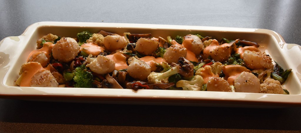 Kamskjell med sesamfrø, ingefær og chili Ingredienser: 8 Kamskjell 4 ss Sesamfrø (gjerne svarte) 30 g Smør Salt Grønnsaker: ½ Sommerkål 100 g Sopp (shitake eller små sjampinjonger) 1 Brokkoli 6 Vårløk 2 fedd Hvitløk 1 ss Ingefær (finhakket) 1-2 Chilier (røde, strimelete) 3 ss Soyasaus 1 ts Sesamolje 1 ts Honning Gochujangmajones: 1 Eggeplomme (romtemerert) 1 ts Risvinseddik 2 – 2½ dl Olje (nøytral) ½ ts Sesamolje ½ - 1 ss Gochujang (sunchang red pepper paste) Salt https://heidisboble.no/ @heidisboble