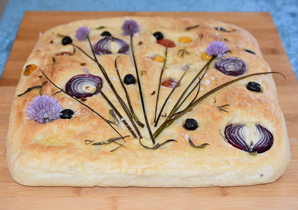 St. Hans-pyntet focaccia Ingredienser: Fordeig (dagen før); 135 g Hvetemel 1 ½ dl Vann (kaldt) 2 g Gjær (fersk – på størrelse med en ert) Dagen du skal bake: 1 kg Hvetemel 2 ss Olje (nøytral) 15 g Salt (2 ts) 5 ½ dl Vann (romtemperert) 20 g Gjær 1 ts Sukker 2 ss Olivenolje Topping: 2 ss Olivenolje Gressløk, rødløk, cherrytomater, Flaksalt, oliven, timian https://heidisboble.no/ @heidisboble
