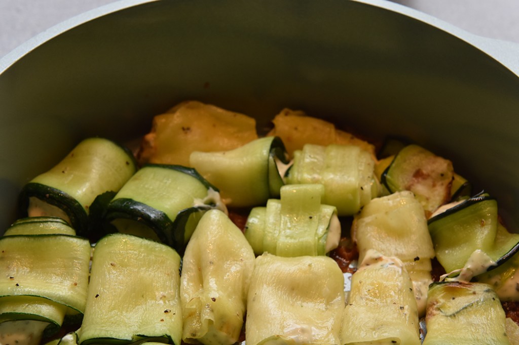 Squash- canneloni Ingredienser Ca 600 g Squash (ca 24 i skiver) 2 ts Olje (oliven) ½ ts Salt ¼ ts Pepper 200 g Kremost (naturell) 1 Egg 3 ss Parmesan (raspet) ½ Mozzarella (i biter) 1 ss Bladpersille (tørket) 1 ss Gressløk (tørket) ¼ ss Oregano (tørket) 2 ss Basilikum (fersk, hakket) Tomatsaus: 2 ss Oliven olje ½ Løk (hakket) 1 Gulrot (hakket) 1 stilk Stangselleri (hakket) 1 fedd Hvitløk (hakket) ¼ Chili (rød – uten frø) eller (kajennepepper) 1 bx Hermetiske tomater 1 dl Hvitvin (eller vann og buljongterning) ½ ts Sukker Bladpersille (hakket) Salt og Pepper https://heidisboble.no/ @heidisboble