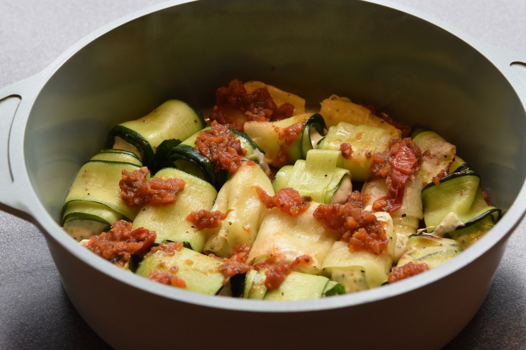 Squash- canneloni Ingredienser Ca 600 g Squash (ca 24 i skiver) 2 ts Olje (oliven) ½ ts Salt ¼ ts Pepper 200 g Kremost (naturell) 1 Egg 3 ss Parmesan (raspet) ½ Mozzarella (i biter) 1 ss Bladpersille (tørket) 1 ss Gressløk (tørket) ¼ ss Oregano (tørket) 2 ss Basilikum (fersk, hakket) Tomatsaus: 2 ss Oliven olje ½ Løk (hakket) 1 Gulrot (hakket) 1 stilk Stangselleri (hakket) 1 fedd Hvitløk (hakket) ¼ Chili (rød – uten frø) eller (kajennepepper) 1 bx Hermetiske tomater 1 dl Hvitvin (eller vann og buljongterning) ½ ts Sukker Bladpersille (hakket) Salt og Pepper https://heidisboble.no/ @heidisboble