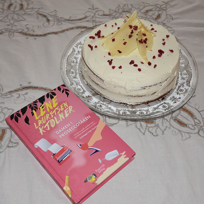 Kjølner, Lene Lauritsen (2021) «Damen i proseccotåken», Fagervik forlag OG Proseccokake  Ingredienser  5 ½ dl 	Prosecco  175 g	Smør (romtemperert) 250 g	Sukker  60 g	Rømme 1 ts	Vaniljeekstrakt 6	Eggehviter (store, romtempererte) 325 g	hvetemel 4 ts	Bakepulver  1¾ dl	Melk  Fyll og topping: 	Bringebær 	Kremfløte  	Hvit sjokolade og tørkete bringebær (valgfritt)  https://heidisboble.no/ @heidisboble
