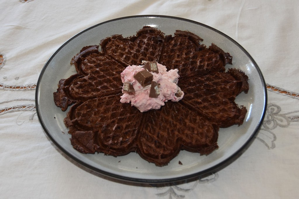 Sjokoladevafler med bringebærkrem Ingredienser 50 g Smør (smeltet) 2 Egg 4½ dl Melk 2½ dl Hvetemel ½ dl Kakaopulver 2 ts Bakepulver 1½ ts Vaniljesukker 3 ss Sukker ½ ts Salt Bringebærkrem: 3 dl Kremfløte 2 dl Bringebærsyltetøy 2 Kvikklunsj https://heidisboble.no/ @heidisboble