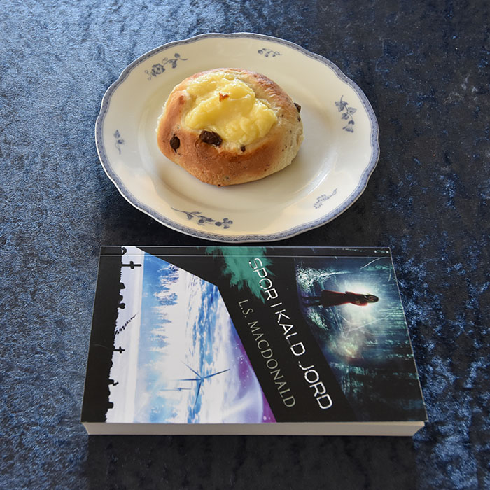 Macdonald, L.S. (2023) «Spor i kald jord» Macademics Forlag og "Shellboller" (boller med sjokoladeboter og vaniljekrem) Ingredienser: 1 l Hvetemel 1 pk Gjær 1 dl Sukker 1 ts Kardemomme 3 ½ dl Melk 100 g Margarin 100 g Kokesjokolade (grov hakket) 1 Egg til pensling (valgfritt) Vaniljekrem: 5 dl Melk 1 Egg 40 g Smør 100 g Sukker 1 ss Vaniljesukker 35 g Maisenna https://heidisboble.no/ @heidisboble